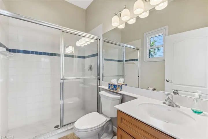 Bathroom featuring vanity, toilet, and a shower stall
