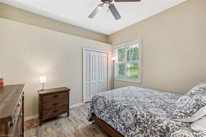 Bedroom with a closet, a ceiling fan, baseboards, and wood finished floors
