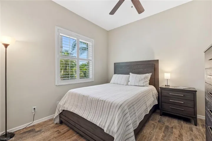 Bedroom featuring baseboards, wood finished floors, and a ceiling fan