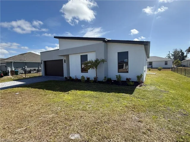 View of front of property featuring stucco siding, a garage, and decorative driveway