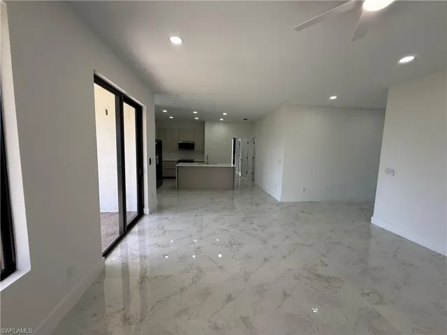 Spare room featuring light marble finish floors, ceiling fan, and recessed lighting