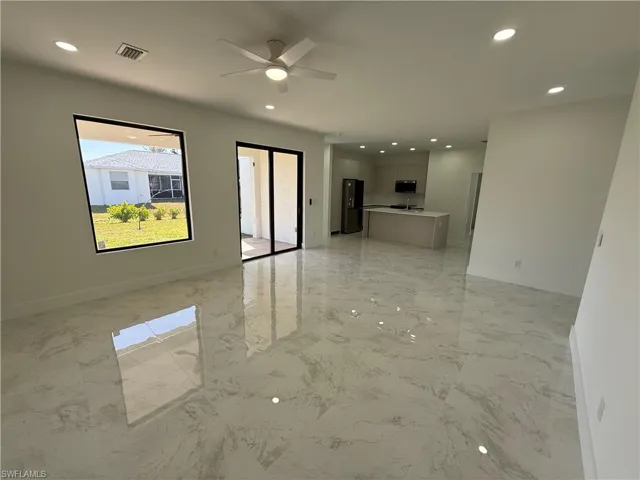 Unfurnished living room with recessed lighting, ceiling fan, and light marble finish flooring