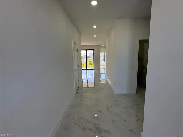 Corridor featuring recessed lighting and light marble finish floors