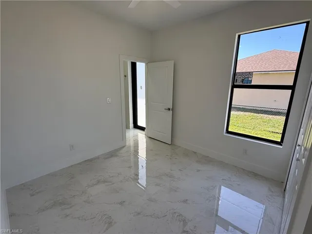 Spare room with light marble finish flooring and a ceiling fan