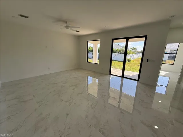 Spare room featuring a ceiling fan and light marble finish floors