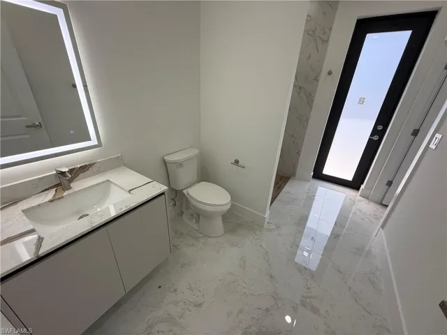 Bathroom featuring vanity and light marble finish floors