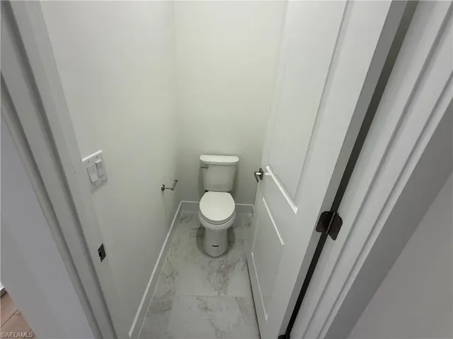 Bathroom with light marble finish flooring and baseboards