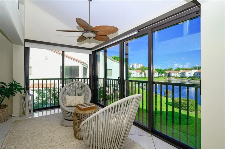 Extended living room with open lanai and lake view with water feature display, steps away from the pool and beach access gate to Vanderbilt Beach.