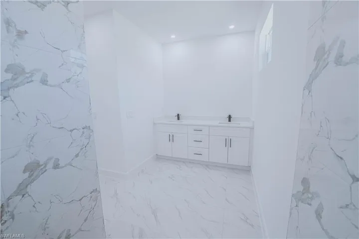 Bathroom featuring tile patterned floors and double sink vanity