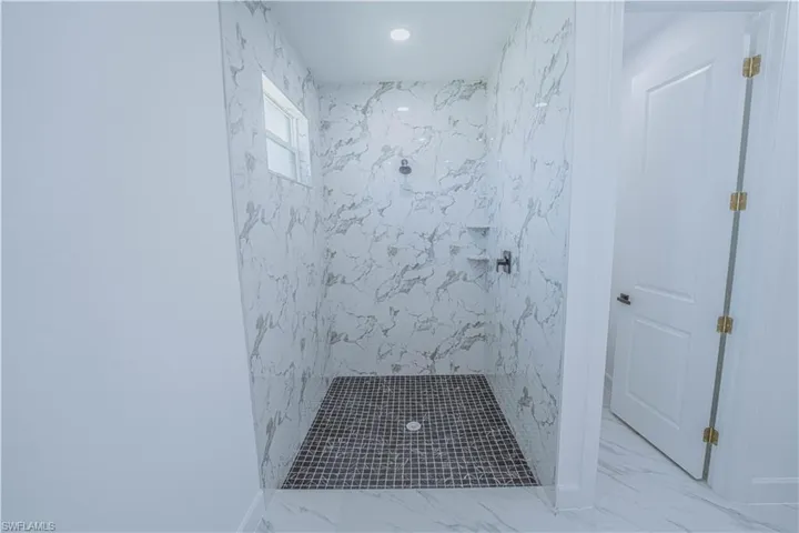 Bathroom with tiled shower and tile patterned flooring