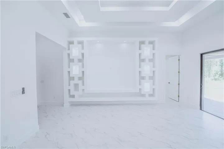 Unfurnished room featuring tile patterned floors and a tray ceiling