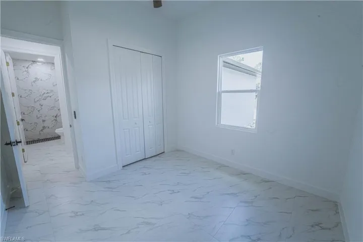 Unfurnished bedroom with a closet and light tile patterned floors