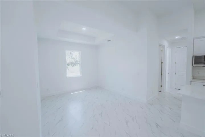 Unfurnished room with a raised ceiling and light tile patterned floors