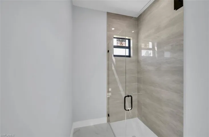 Bathroom featuring a stall shower and baseboards