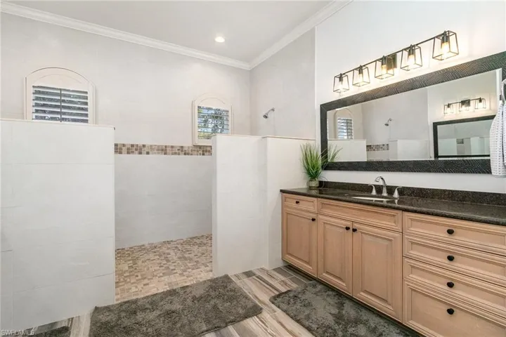 Full bath featuring vanity, wood tiled floor, a walk in shower, and ornamental molding