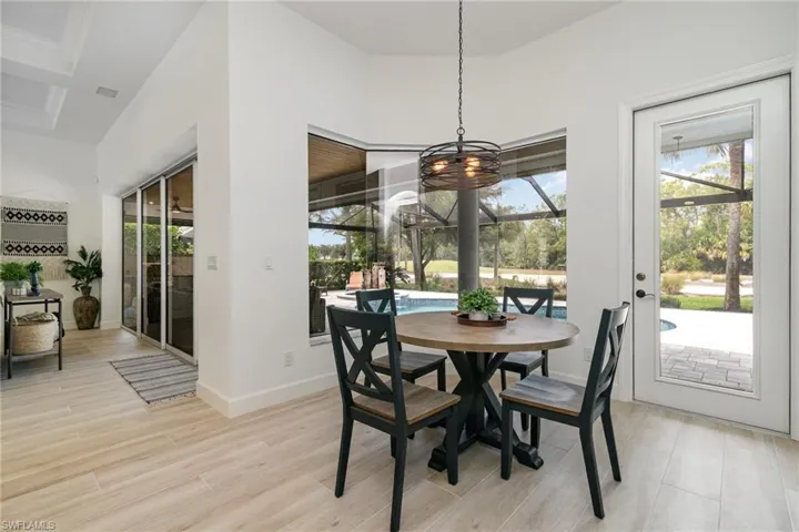 Dining area featuring an inviting chandelier, plenty of natural light, baseboards, and light wood-style floors