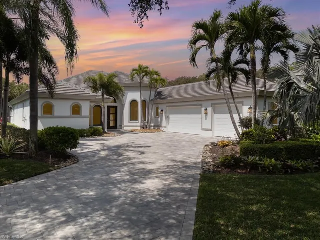 Mediterranean / spanish-style house with a tile roof, decorative driveway, stucco siding, and an attached garage