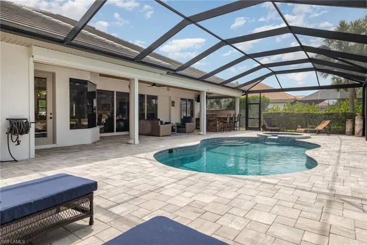 View of swimming pool featuring a pool with connected hot tub, a patio area, an outdoor hangout area, outdoor dry bar, and ceiling fan