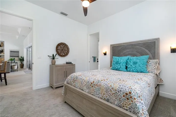 Bedroom featuring carpet floors, baseboards, ceiling fan, and visible vents