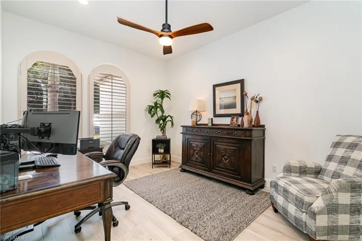 Office space with baseboards, wood finished floors, and ceiling fan