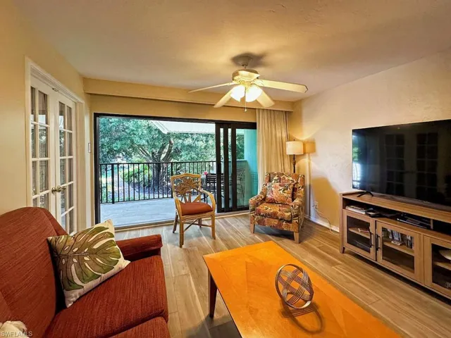 Living area featuring a ceiling fan, light wood finished floors, and french doors