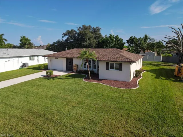 Single story home featuring stucco siding, an attached garage, driveway, and roof with shingles
