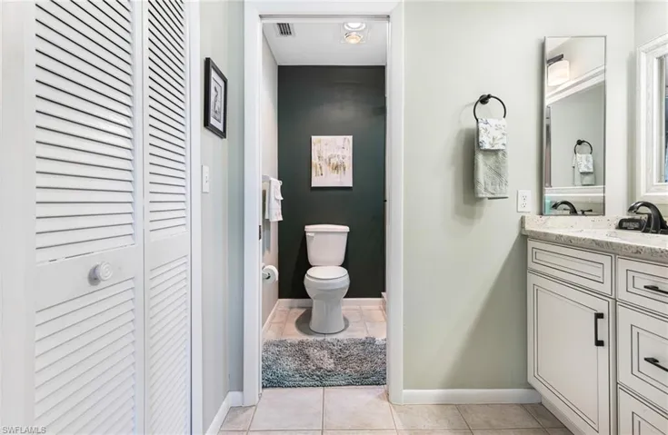 Bathroom featuring vanity, toilet, and tile patterned floors