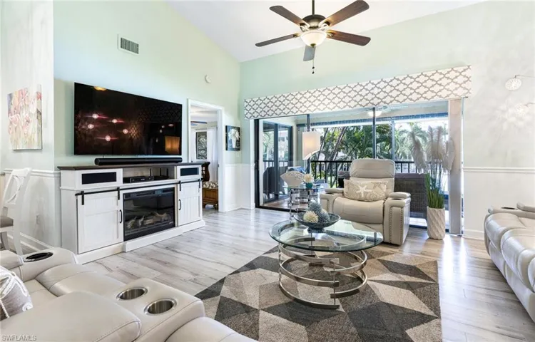 Living room featuring light hardwood / wood-style flooring, ceiling fan, and high vaulted ceiling