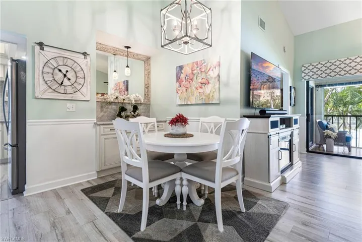Dining space featuring light hardwood / wood-style floors, a chandelier, and high vaulted ceiling