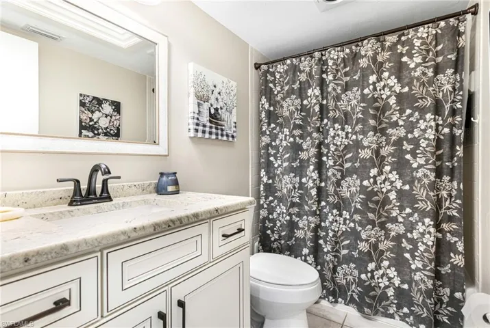 Bathroom featuring tile patterned flooring, toilet, and vanity