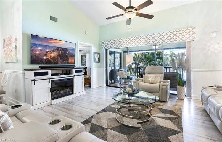 Living room with high vaulted ceiling, light wood-type flooring, and ceiling fan