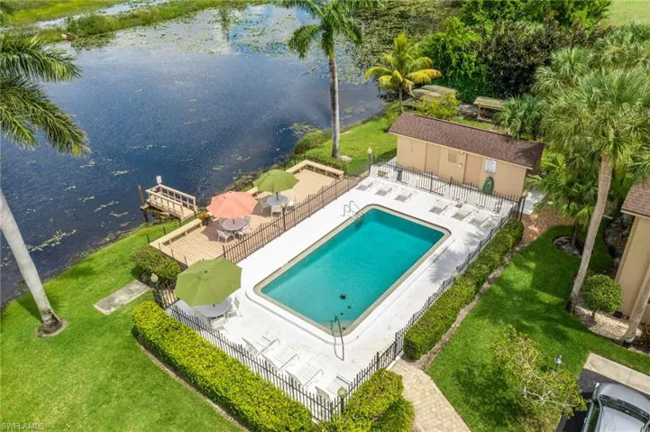 View of pool with a water view, a yard, and a patio area