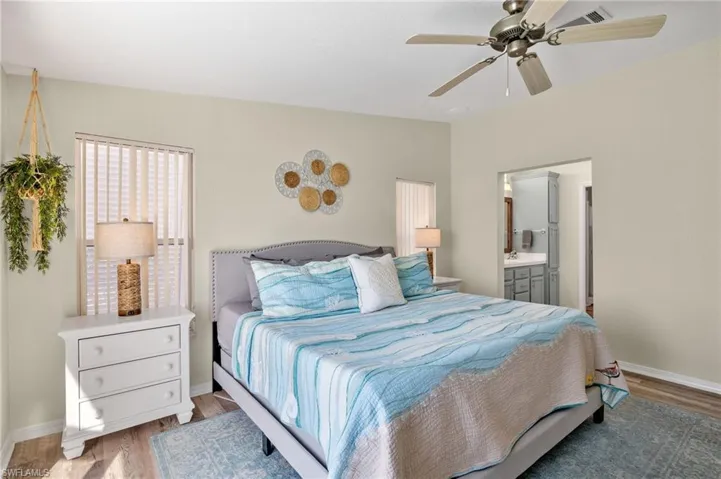 Bedroom featuring wood-type flooring, sink, ensuite bath, and ceiling fan