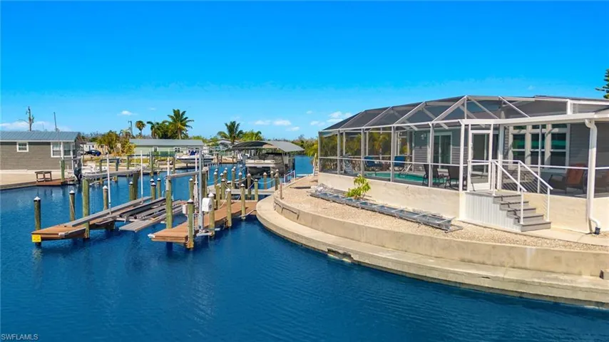 View of dock featuring glass enclosure and a water view