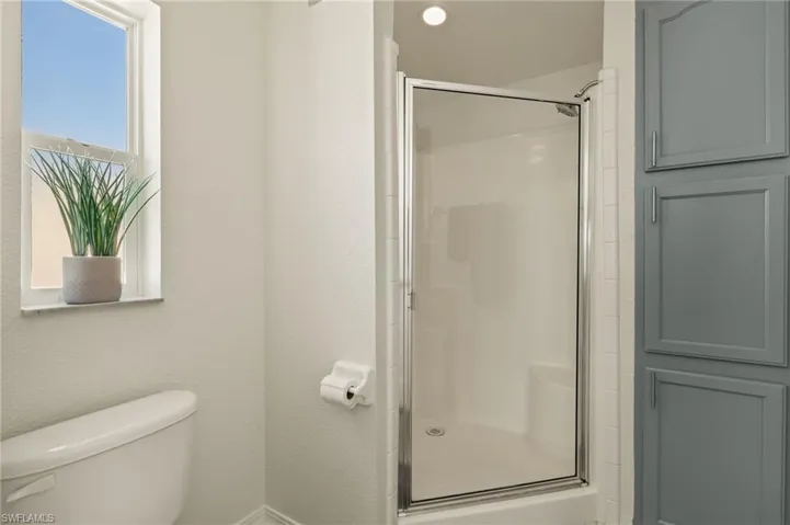 Bathroom with a shower with shower door and toilet
