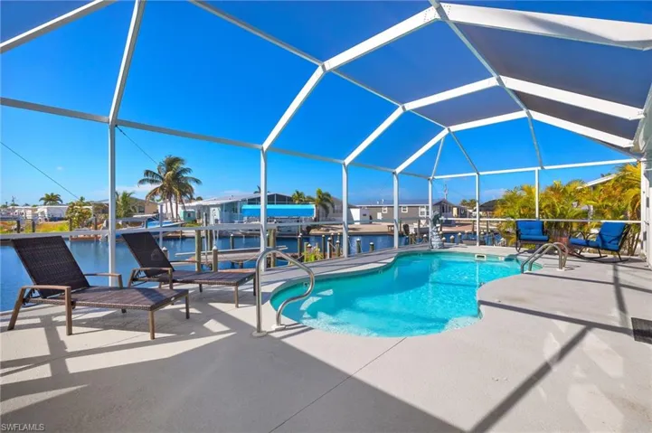 View of swimming pool with a patio area, a lanai, and a water view