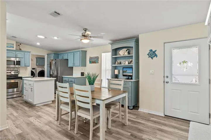 Dining space featuring washer and dryer, light hardwood / wood-style floors, lofted ceiling, and ceiling fan
