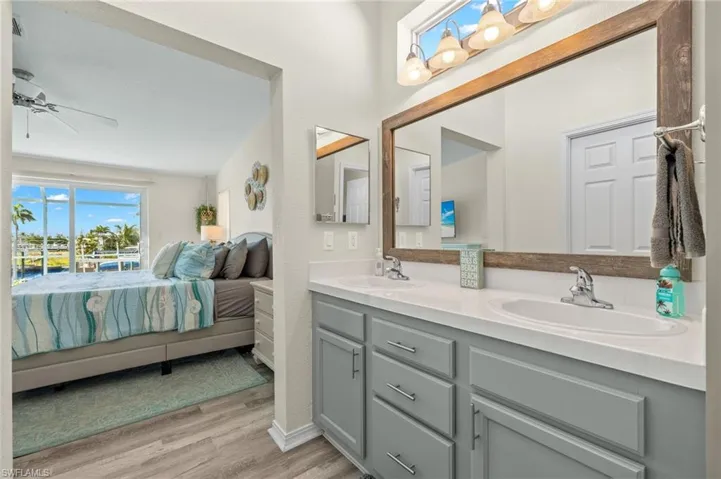 Bathroom with ceiling fan, double sink vanity, and wood-type flooring