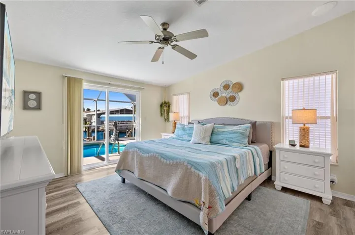 Bedroom with ceiling fan, light hardwood / wood-style floors, and access to outside