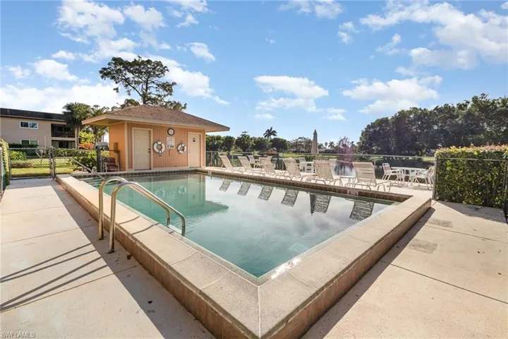 View of pool with sundeck, patio and restrooms.