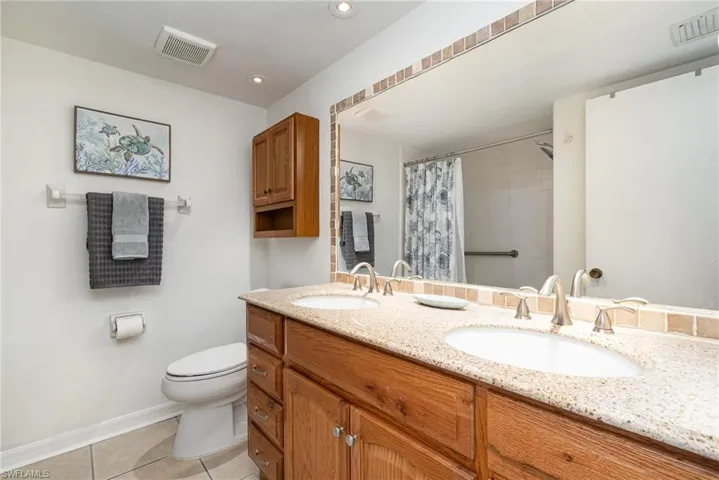 Guest Bathroom with double vanity, updated toilet and tub/shower combo.