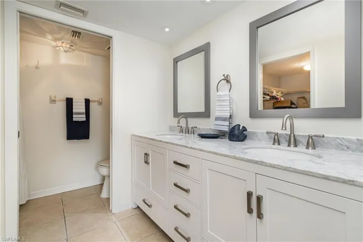 Primary Bathroom featuring new, double vanity, new mirrors, updated toilet and shower.