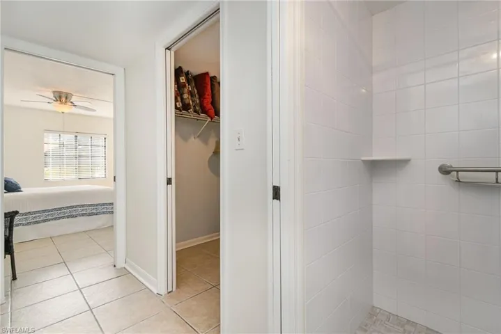 Primary Bathroom with updated tiled shower and toilet, separated by pocket door for additional privacy.