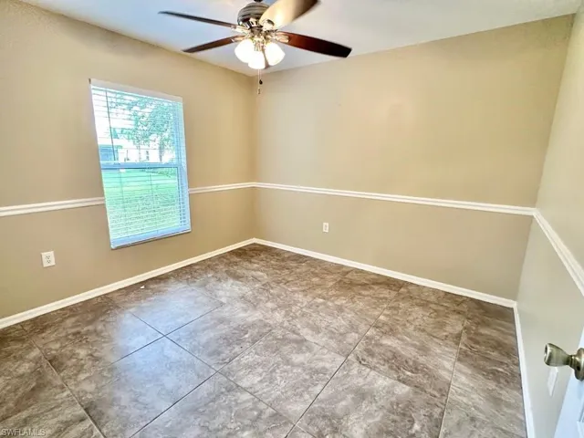 Spare room featuring a ceiling fan and tile patterned floors
