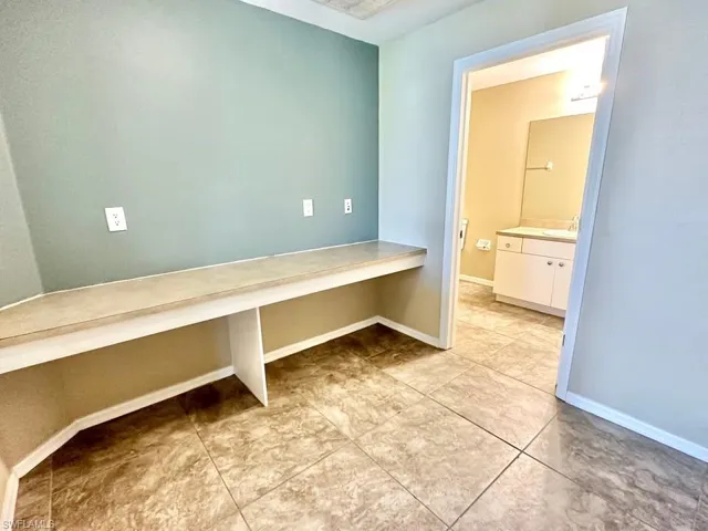 Unfurnished office featuring baseboards and a sink