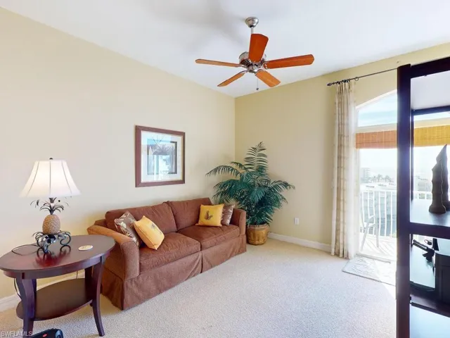 Carpeted living room featuring ceiling fan