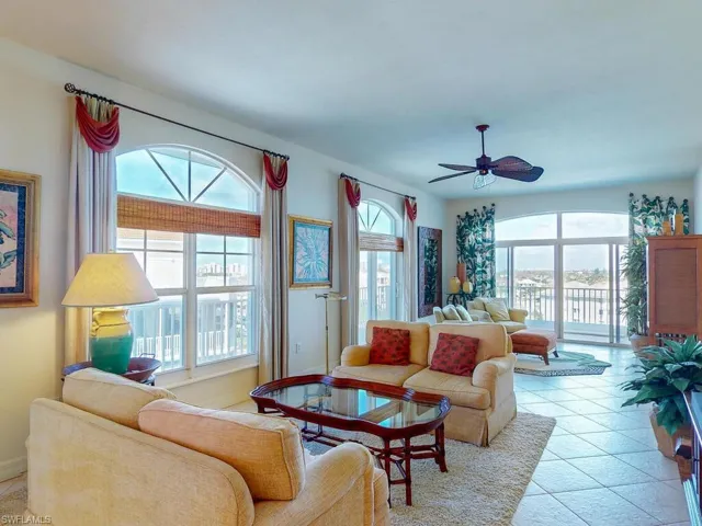 Living room featuring a wealth of natural light, ceiling fan, and light tile patterned floors
