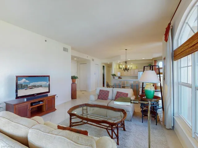 Living room featuring light tile patterned flooring and a notable chandelier