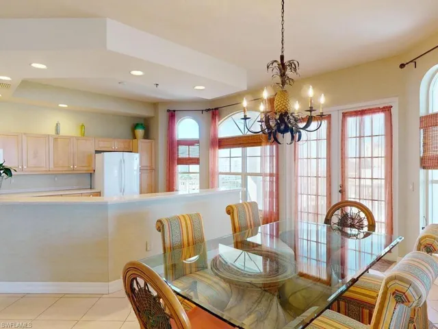 Dining room featuring a wealth of natural light, a notable chandelier, and light tile patterned floors
