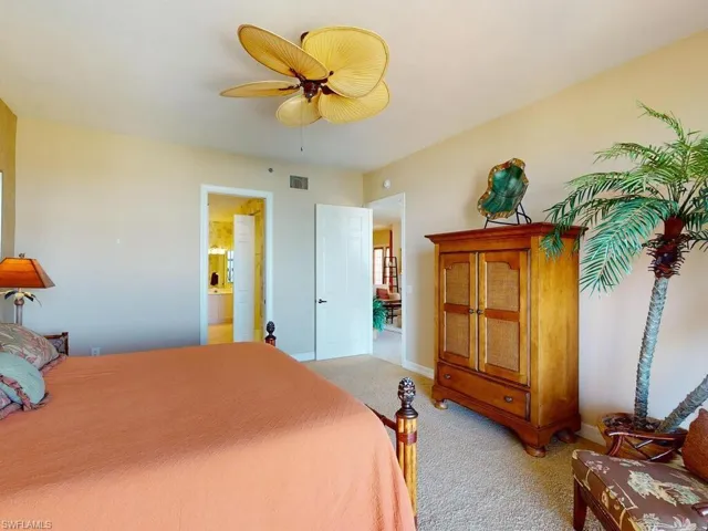 Bedroom featuring light colored carpet, ceiling fan, and connected bathroom